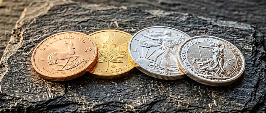 Gold bars and silver coins stacked together — best inflation hedge assets comparison 2025 2026